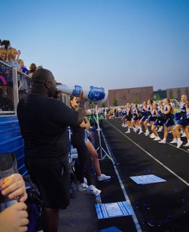 Photo Courtesy: Emma Chisolm. Coach Niles chants along with the cheerleaders on the sidelines. This was his first season as the Varsity Cheer Coach.
