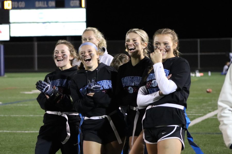 Members of the Senior Powderpuff team laugh as their team celebrates a touchdown. The seniors edged out the sophomores in the Powderpuff Championship Game.