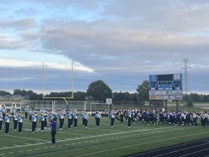 Photo courtesy: Rachel Bjorkman '24. Students of the Class of 2024 sprint across the field as the band plays. An underclassman was even sent off the field after he sneaked in.