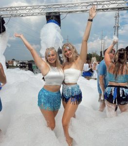 Photo courtesy: Ava First. First and Ellie Smith stand together in a pit of bubbles. Both First and Smith attended their sororities Ice Breaker event, at the University of Alabama.