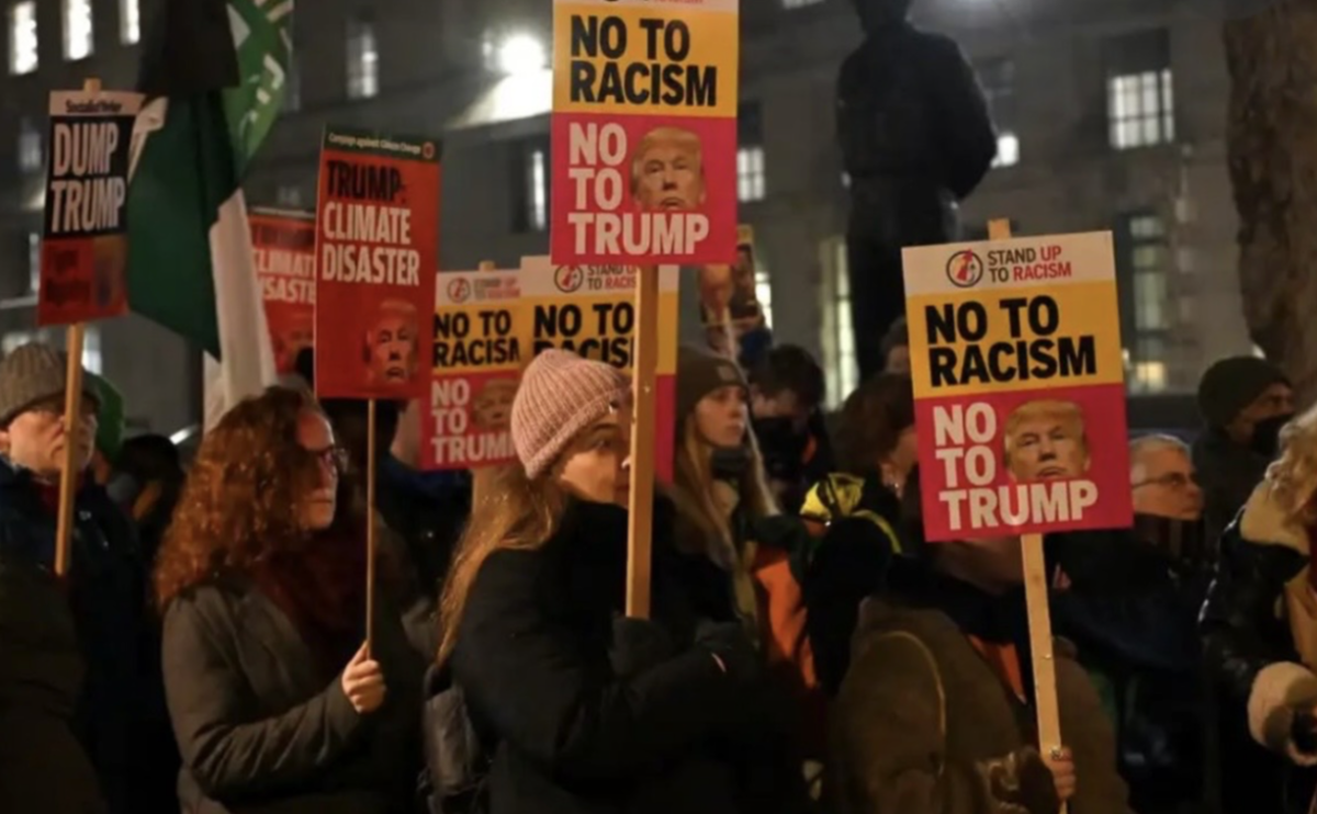  Protestors hold signs to announce their complaint about President Trump’s second term. This protest created a crowd that called for racial justice and opposed the idea of Trump becoming a political leader.
